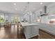 Spacious kitchen island with seating, designer lighting, and stainless steel range hood at 2710 Cambridge Rd, Raleigh, NC 27608