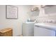 Functional laundry room with white washer, dryer, storage shelves, and decor at 280 Hank Way, Angier, NC 27501