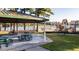 Covered picnic area with tables beside a playground, set against a backdrop of trees and a lake at 280 Hank Way, Angier, NC 27501