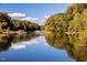 A serene river view reflecting the colorful trees along its banks, creating a peaceful natural setting at 280 Hank Way, Angier, NC 27501