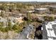 Aerial view showcasing property near golf course and trees with nearby commercial buildings in the distance at 2820 Glenwood Gardens Ln # 101, Raleigh, NC 27608
