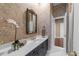 Bathroom with granite counters, patterned wallpaper, and brass fixtures at 2820 Glenwood Gardens Ln # 101, Raleigh, NC 27608