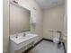 Neutral bathroom featuring a mirror, sink, toilet, paper-towel dispenser, and handrails for accessibility at 2820 Glenwood Gardens Ln # 101, Raleigh, NC 27608