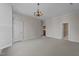 A spacious bedroom with carpet, neutral walls, a vintage chandelier and a side view of the shuttered windows at 2820 Glenwood Gardens Ln # 101, Raleigh, NC 27608