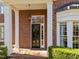 Brick home entrance featuring a black door, white columns, and a decorative hanging light fixture at 2820 Glenwood Gardens Ln # 101, Raleigh, NC 27608