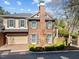 Attractive two-story brick home featuring a chimney, manicured bushes, and an iron gate to backyard at 2820 Glenwood Gardens Ln # 101, Raleigh, NC 27608