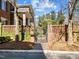 Exterior view of the brick home with a gated entrance with landscaped grounds and a brick walkway leading up to the gate at 2820 Glenwood Gardens Ln # 101, Raleigh, NC 27608