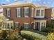 Exterior of a brick home featuring dark-trimmed windows and door, surrounded by lush greenery at 2820 Glenwood Gardens Ln # 101, Raleigh, NC 27608