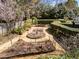 A serene garden is surrounded by manicured hedges, with a birdbath centerpiece and stone pathways at 2820 Glenwood Gardens Ln # 101, Raleigh, NC 27608