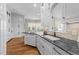 View of the kitchen featuring dark countertops, a sink and white cabinetry at 2820 Glenwood Gardens Ln # 101, Raleigh, NC 27608