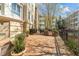Stone paved patio with grill and decorative bushes in front of beige building at 2820 Glenwood Gardens Ln # 101, Raleigh, NC 27608