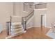 Elegant staircase with carpeted treads, wood floors, and iron railings leads to the upper level at 2820 Glenwood Gardens Ln # 101, Raleigh, NC 27608