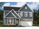 Charming two-story home featuring blue siding, brick accents, and a two-car garage. Well manicured lawn at 3201 Shannon Woods Lane # 19, Apex, NC 27523