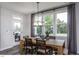 Bright dining room featuring a wooden table, modern lighting, and large windows offering a pleasant view at 33 White Azalea Way, Homesite 80, Benson, NC 27504