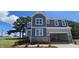 A charming two-story house with a stone foundation and integrated two-car garage at 33 White Azalea Way, Homesite 80, Benson, NC 27504