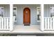 Inviting front porch with rocking chairs and a beautiful wood door at 3650 Durwood Ln, Raleigh, NC 27604