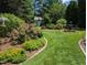 Expansive backyard featuring a decorative water fountain, a storage shed, and professionally landscaped garden beds at 3708 Wesley Ridge Dr, Apex, NC 27539