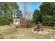 Landscaped backyard with water fountain and shed providing a serene outdoor retreat at 3708 Wesley Ridge Dr, Apex, NC 27539