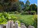 Manicured backyard featuring lush lawn, mature trees, and colorful garden beds offering serene outdoor living at 3708 Wesley Ridge Dr, Apex, NC 27539