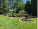 Immaculate backyard with a stone fountain, meticulously manicured lawn, and lush greenery at 3708 Wesley Ridge Dr, Apex, NC 27539