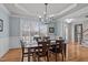 Inviting dining room featuring hardwood floors, modern chandelier, and expansive windows offering abundant sunlight at 3708 Wesley Ridge Dr, Apex, NC 27539