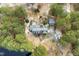 An aerial view of a brick home with a circular driveway and lush surrounding greenery and lake at 3715 Rawls Church Rd, Fuquay Varina, NC 27526