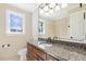 Bathroom featuring a granite countertop, vanity, toilet, and large mirror at 3715 Rawls Church Rd, Fuquay Varina, NC 27526