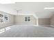 Large bonus room with neutral carpet, windows, and white trim at 3715 Rawls Church Rd, Fuquay Varina, NC 27526