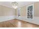 Dining room features hardwood floors, wainscoting, a chandelier and large windows at 3715 Rawls Church Rd, Fuquay Varina, NC 27526