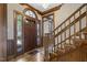 Inviting foyer featuring hardwood floors, decorative trim, chandelier, wooden door with glass panes, and staircase at 3715 Rawls Church Rd, Fuquay Varina, NC 27526