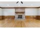 Spacious living room features hardwood floors, brick fireplace, ceiling fan and decorative wood trim at 3715 Rawls Church Rd, Fuquay Varina, NC 27526