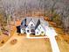 Aerial view of a modern farmhouse with a sprawling lawn, long driveway, and wooded surroundings at 3901 Laurel Creek Ln, Wake Forest, NC 27587