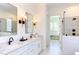Bright bathroom features a double vanity, a glass enclosed shower, and a soaking tub at 3901 Laurel Creek Ln, Wake Forest, NC 27587