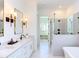 Bright bathroom features a double vanity, a glass enclosed shower, and a soaking tub at 3901 Laurel Creek Ln, Wake Forest, NC 27587