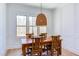Dining room boasts a rustic wood table, decorative lighting, and views of the outdoors at 3901 Laurel Creek Ln, Wake Forest, NC 27587