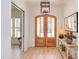 Elegant foyer featuring hardwood floors, double glass doors, stylish light fixture, and decorative table at 3901 Laurel Creek Ln, Wake Forest, NC 27587