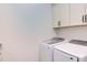 Bright laundry room with white cabinets, washer, and dryer at 3901 Laurel Creek Ln, Wake Forest, NC 27587