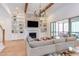 Bright living room with a stone fireplace, built-in shelving, hardwood floors, and a comfortable gray sofa at 3901 Laurel Creek Ln, Wake Forest, NC 27587