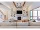 Bright living room with a stone fireplace, built-in shelving, hardwood floors, and access to a screened porch at 3901 Laurel Creek Ln, Wake Forest, NC 27587