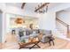Open-concept living room seamlessly blending with the kitchen, featuring hardwood floors and a stylish gray sofa at 3901 Laurel Creek Ln, Wake Forest, NC 27587