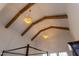 The vaulted ceiling of the main bedroom features stylish light fixtures and wooden beam accents at 3901 Laurel Creek Ln, Wake Forest, NC 27587