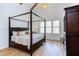 This main bedroom features a striking four-poster bed, wood floors and beam, and large windows at 3901 Laurel Creek Ln, Wake Forest, NC 27587