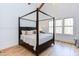 This main bedroom features a striking four-poster bed, wood floors and beam, and large windows at 3901 Laurel Creek Ln, Wake Forest, NC 27587