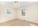 Bedroom featuring neutral walls, carpet floor, and natural light from the two windows at 4508 Regis Ave, Durham, NC 27705