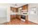 Kitchen with wood cabinets, laminate floor, white appliances, and a double stainless steel sink at 4508 Regis Ave, Durham, NC 27705