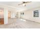 Spacious living room with neutral carpet, white walls, a ceiling fan and multiple windows at 4508 Regis Ave, Durham, NC 27705