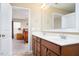 Bathroom featuring a double sink vanity, large mirror, and a view to the main bedroom at 5315 Glenmorgan Ln, Raleigh, NC 27616