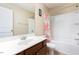 Bathroom featuring a dark wood vanity, white sink, and bathtub-shower combination with a floral curtain at 5315 Glenmorgan Ln, Raleigh, NC 27616