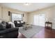 A well-lit living room with dark sofas, decorative pillows and a sliding door enhances the home's cozy feel at 5315 Glenmorgan Ln, Raleigh, NC 27616