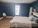 Spacious bedroom with laminate floors, a large window and blue accent wall at 614 Oak St, Burlington, NC 27215